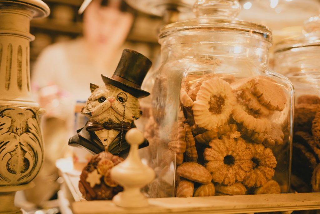 A cat statue and cookies sit together.