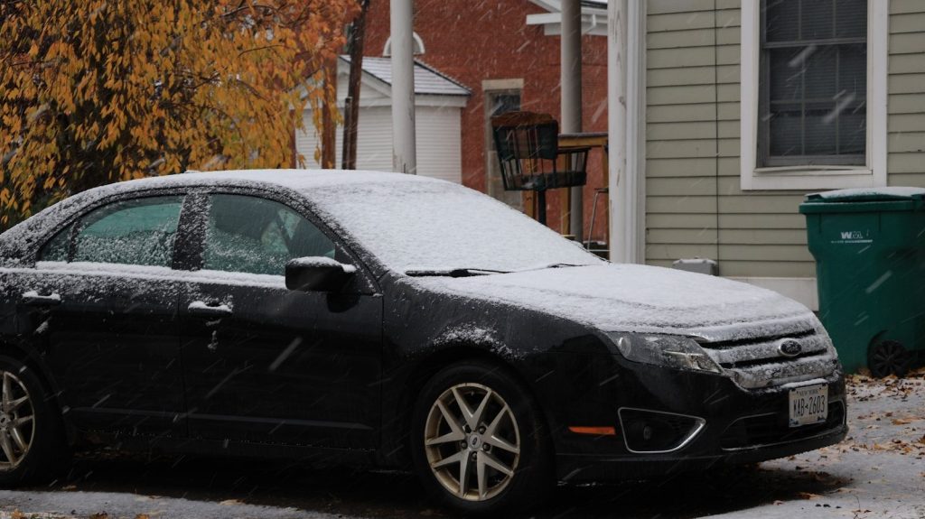 A black car covered in light snow