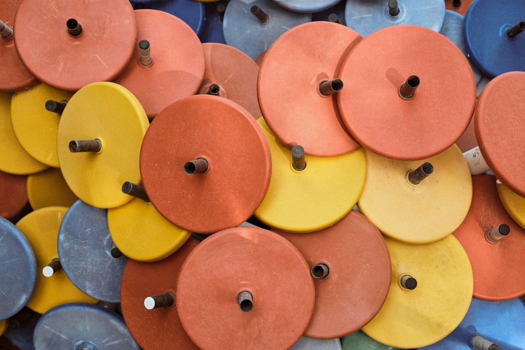 a pile of different colored discs with holes in them