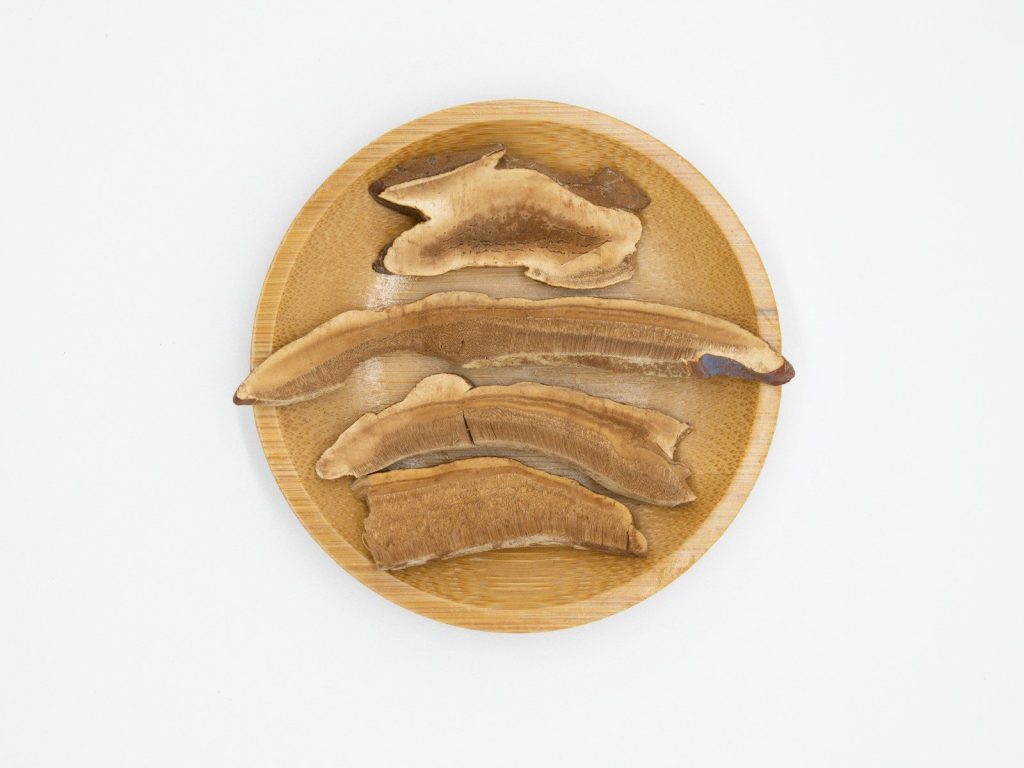 a wooden plate topped with sliced bananas on top of a white wall
