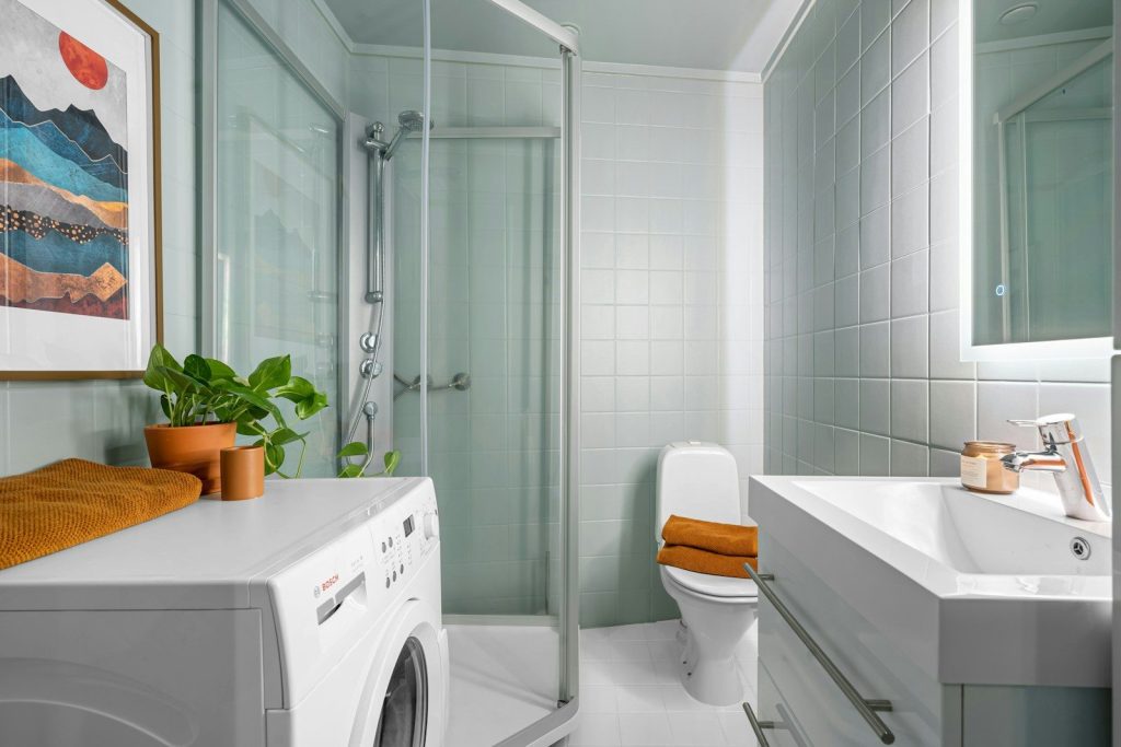 A bathroom with a washer and a toilet