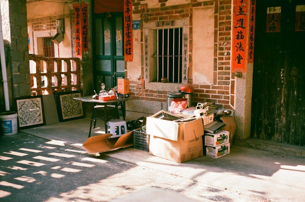 Old building exterior with stacked boxes and items.