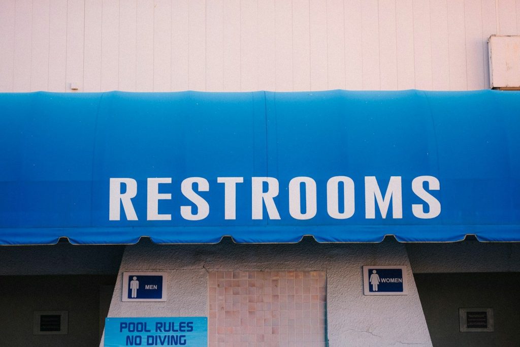 Restrooms sign on blue awning above entrances
