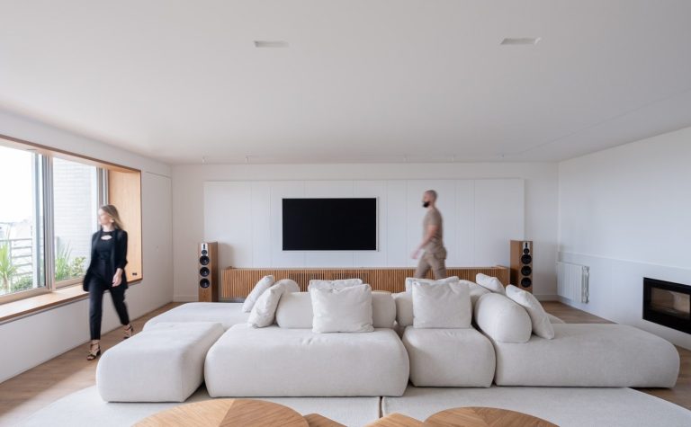 Modern living room with large modular sofa and television.