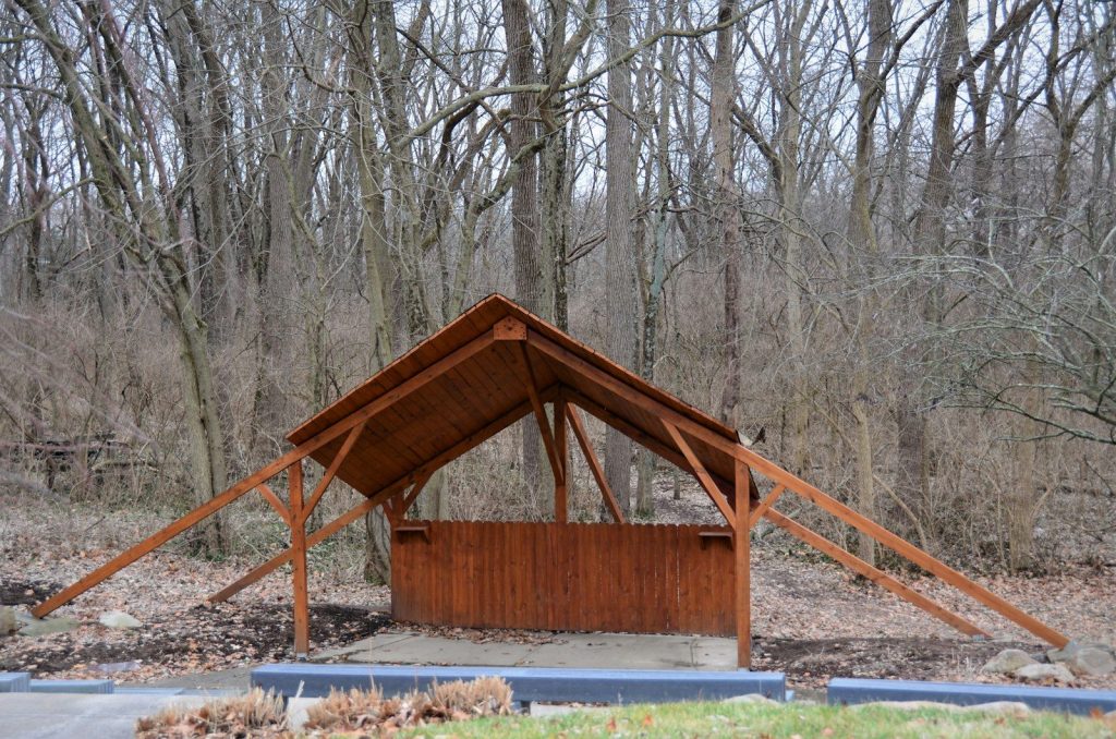 a wooden structure in the middle of a forest