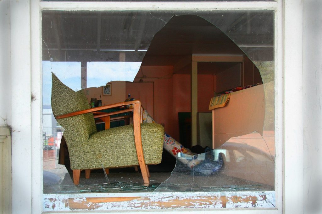 a broken glass window with a chair in it