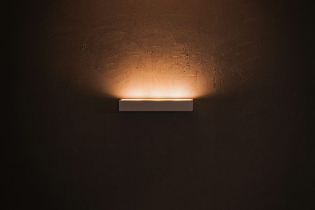 white light bulb turned on in dim lit room