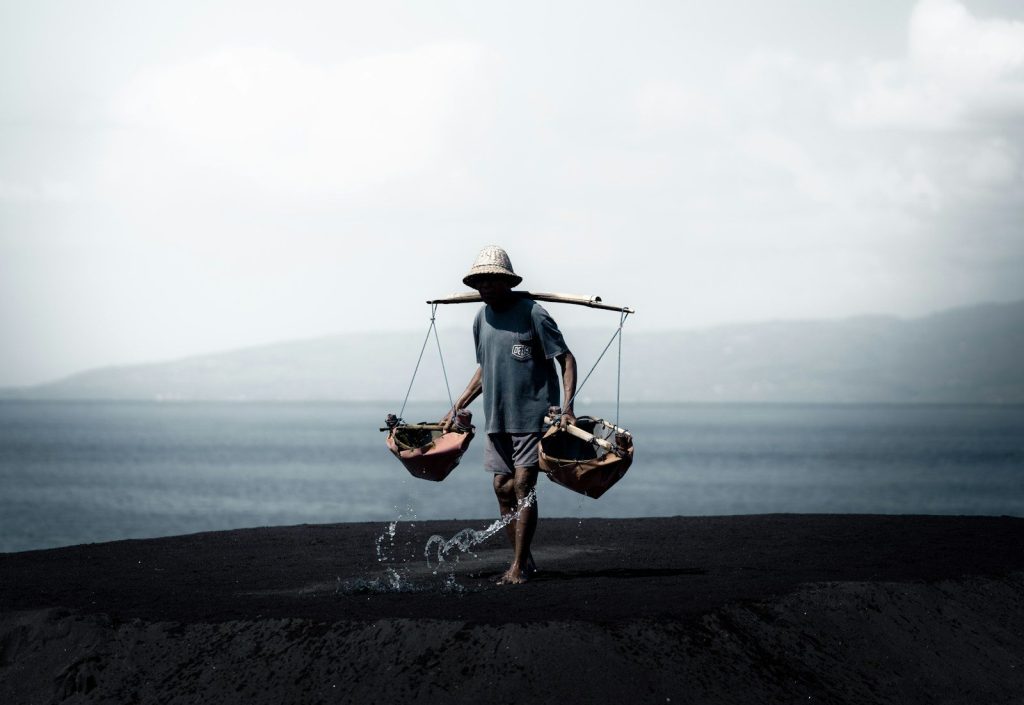 A man carrying two buckets on his back