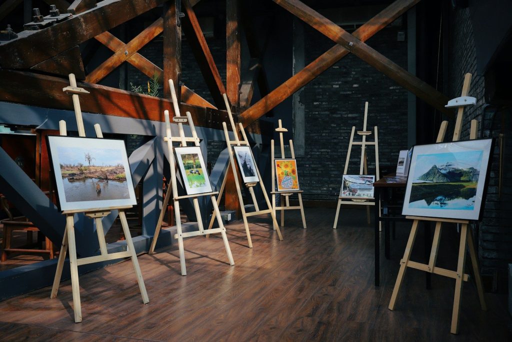 five assorted paintings on easels