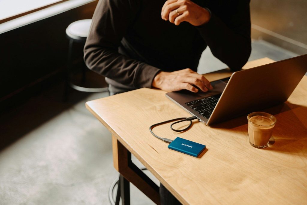 A man sitting at a table using a laptop computer