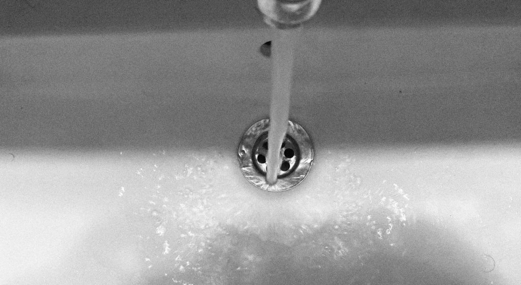 Water flows from the faucet into the sink.