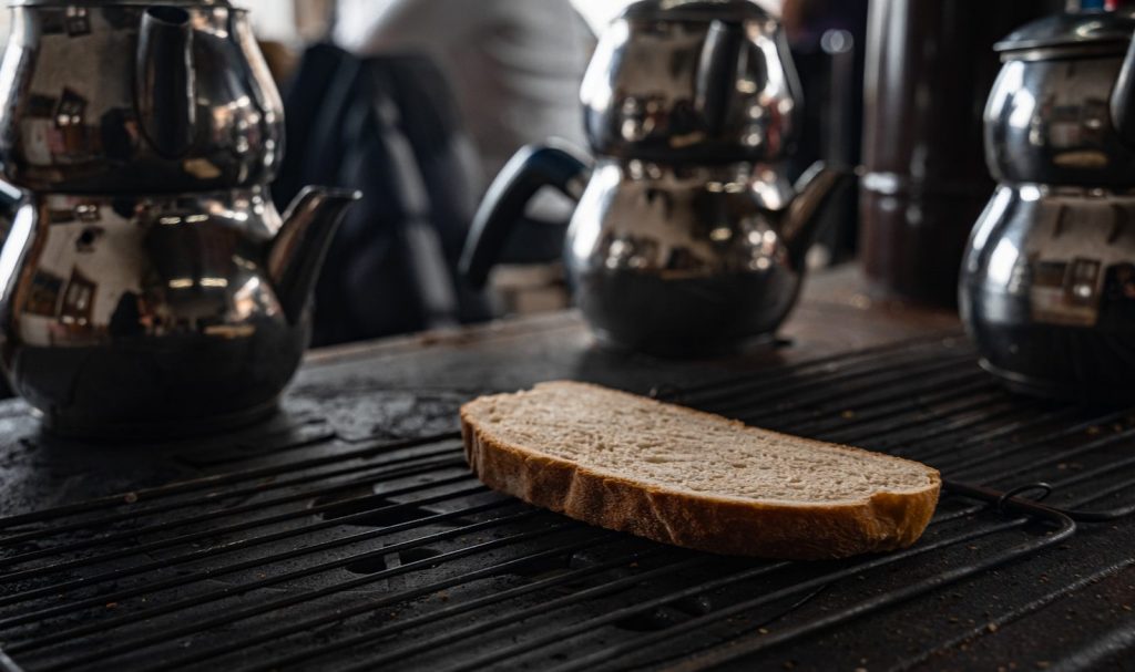 Slice of bread on a grill with teapots