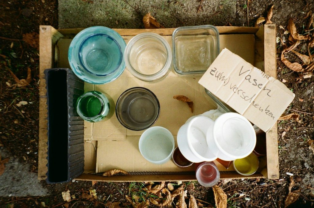 Various small containers and jars in a wooden crate.