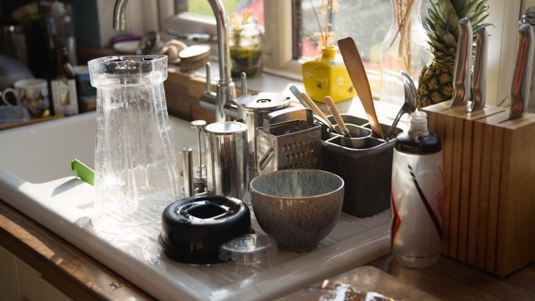 a kitchen sink with a variety of kitchen utensils