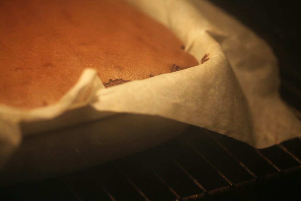 A cake baking in an oven on a rack.