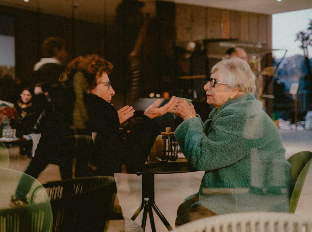 A woman sitting at a table with a cup of coffee