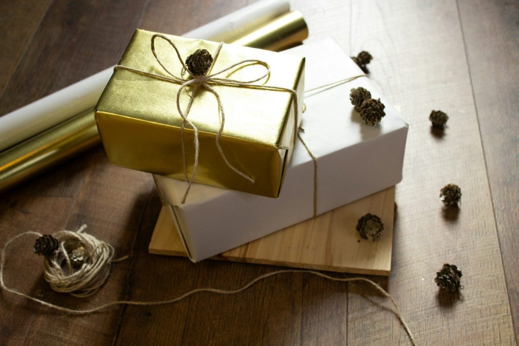 two wrapped presents sitting on top of a wooden table