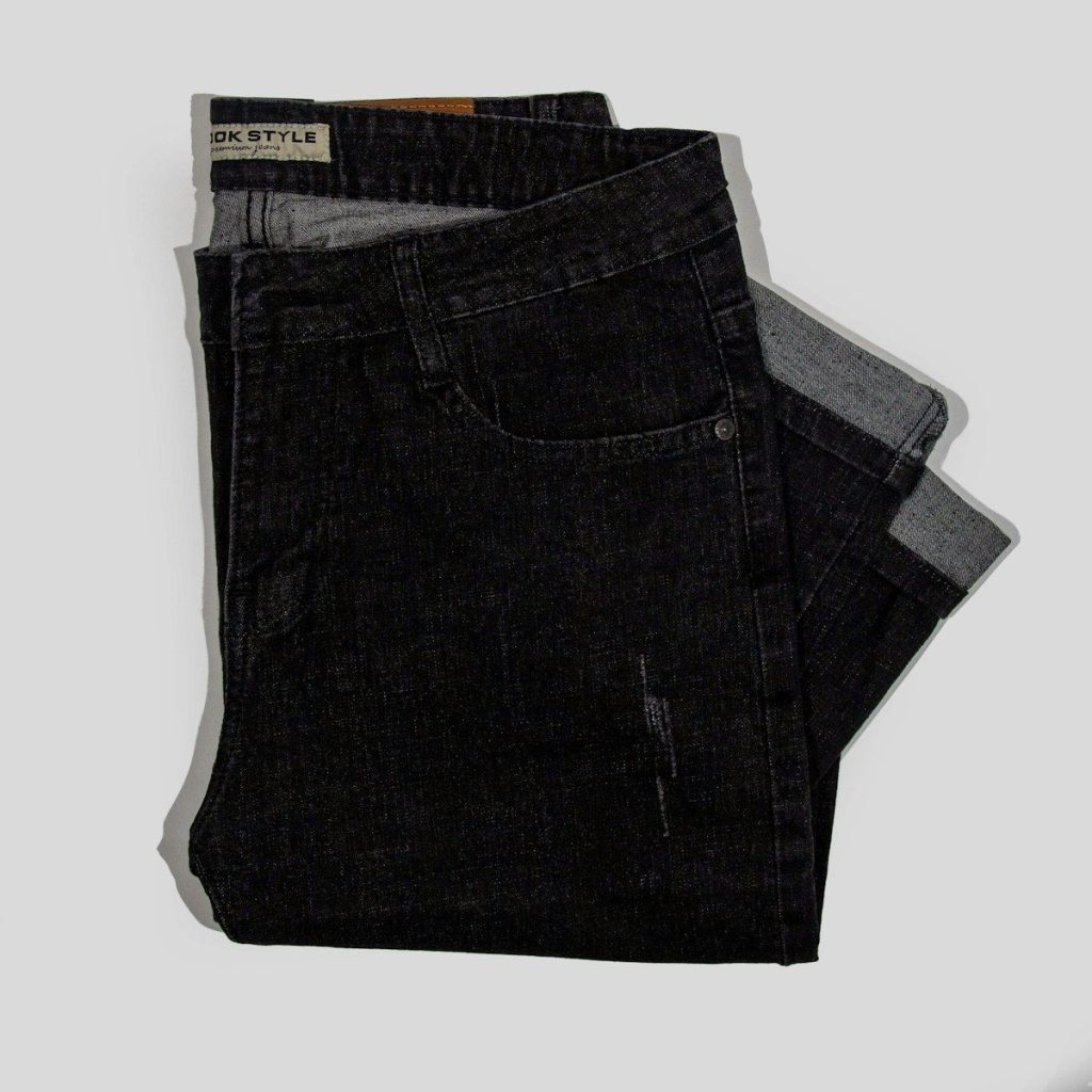 a pair of black jeans sitting on top of a white surface