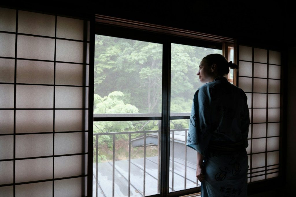 a woman in a kimono looking out a window