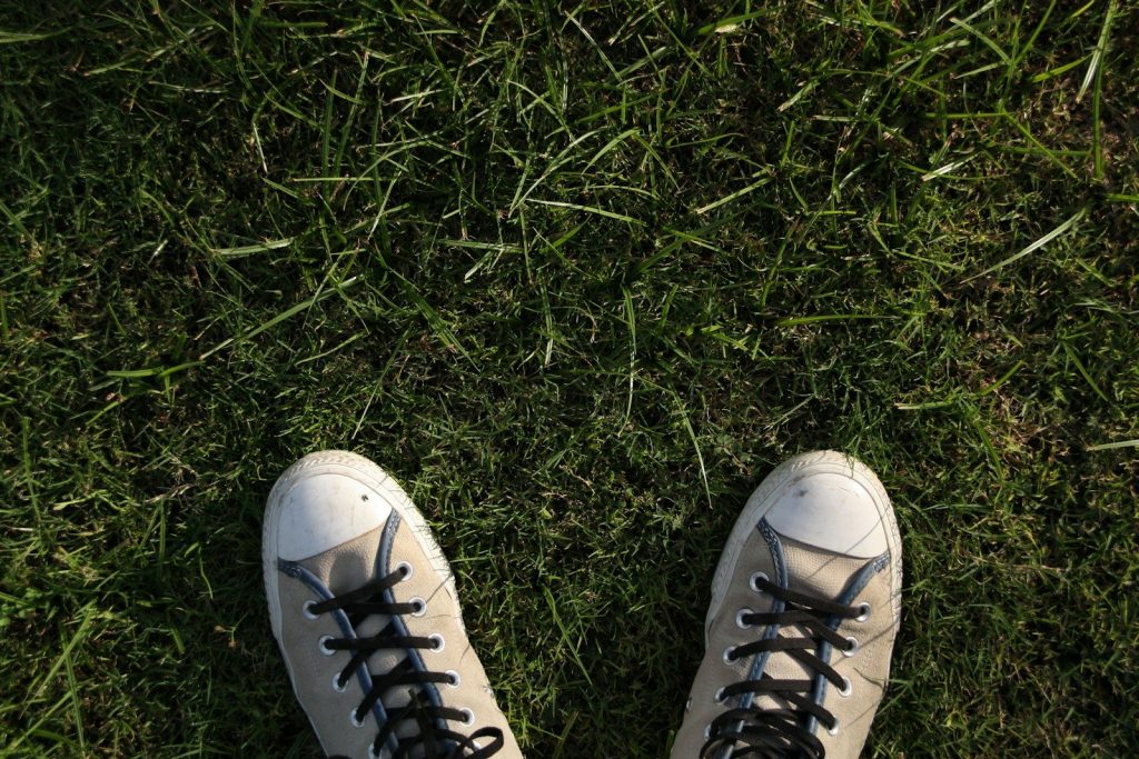 a pair of white shoes with black laces on them