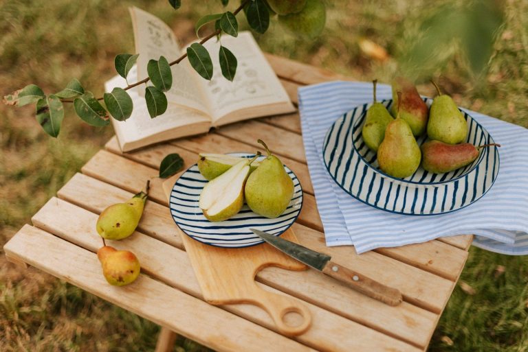 A wooden table topped with bowls of fruit