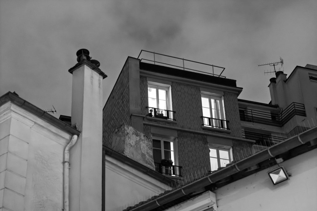 Buildings with illuminated windows against a cloudy sky