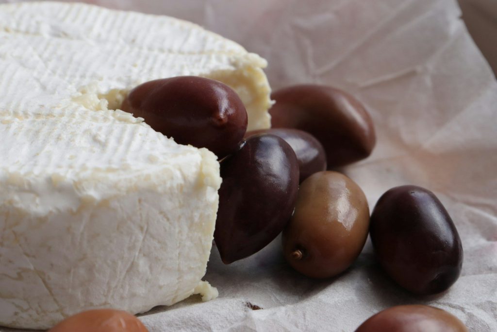 Cheese and olives sit beautifully displayed.
