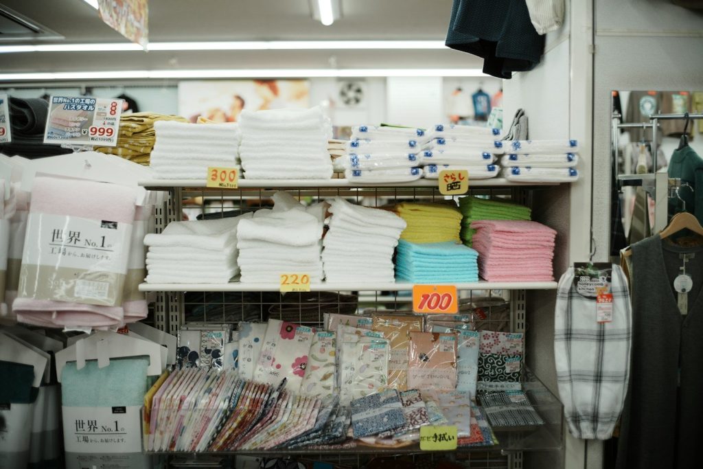 Shelves of folded towels and clothing in a store.