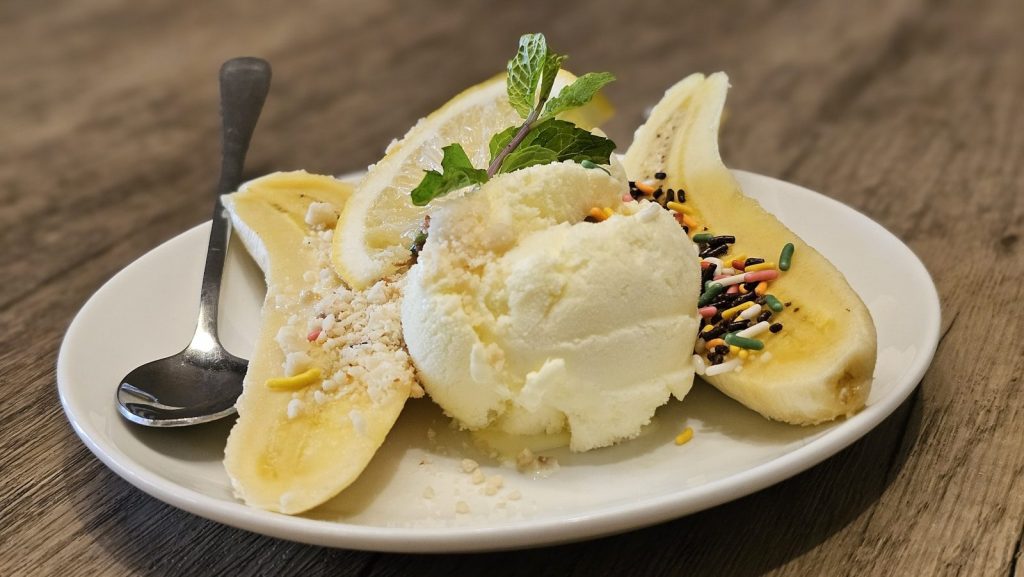 Banana split with ice cream on a plate.
