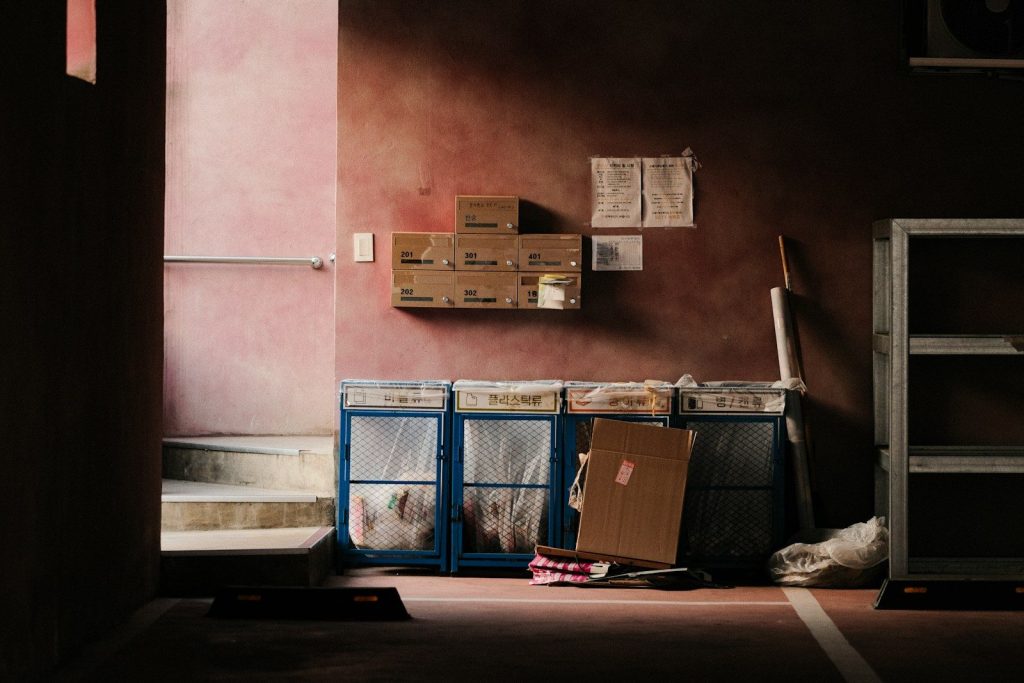 A cluttered workspace with boxes and a red wall.