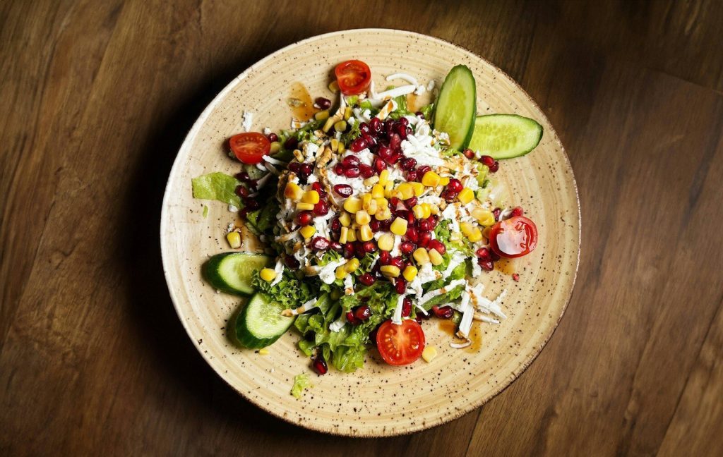 a plate of salad on a wooden table