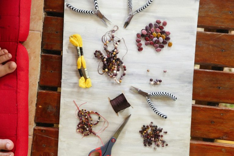 a table topped with lots of beads and scissors