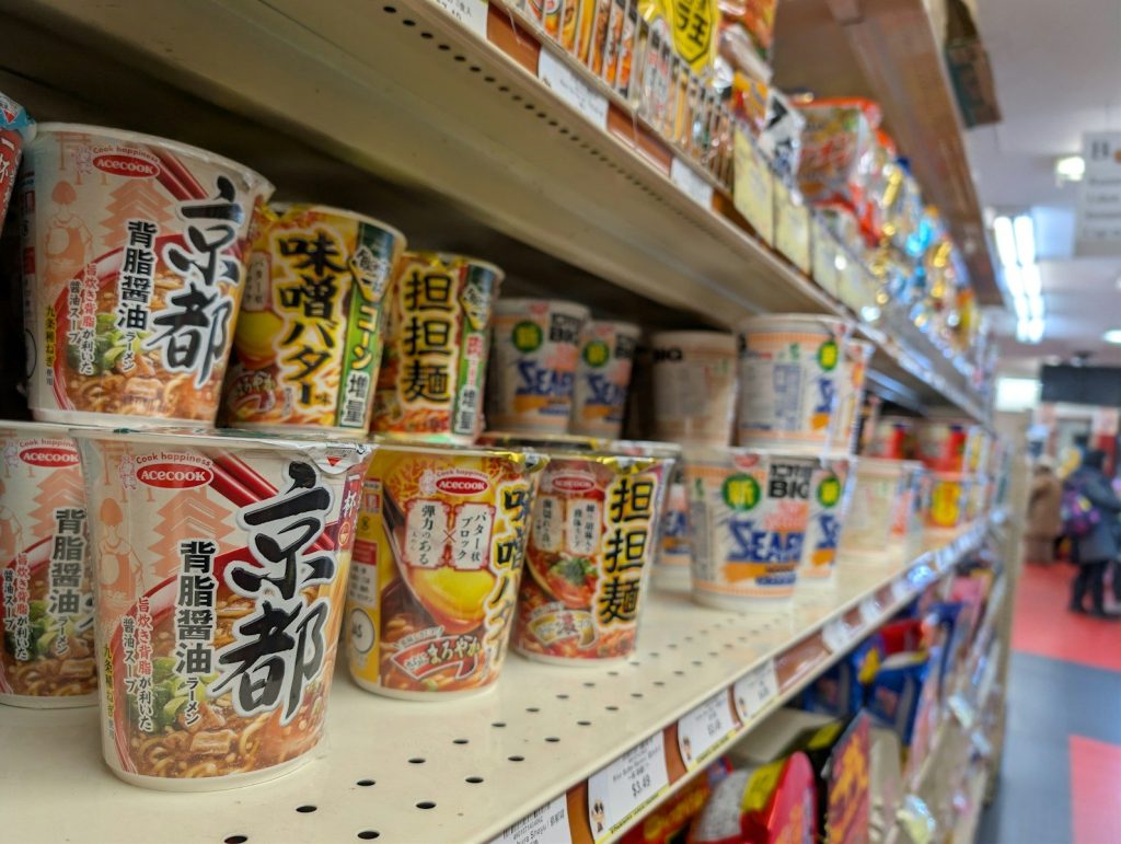 Shelves stocked with assorted cup noodle products.