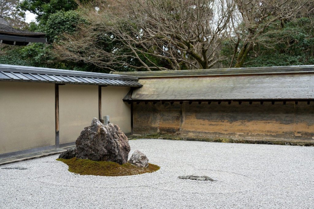 a rock in a gravel area next to a building