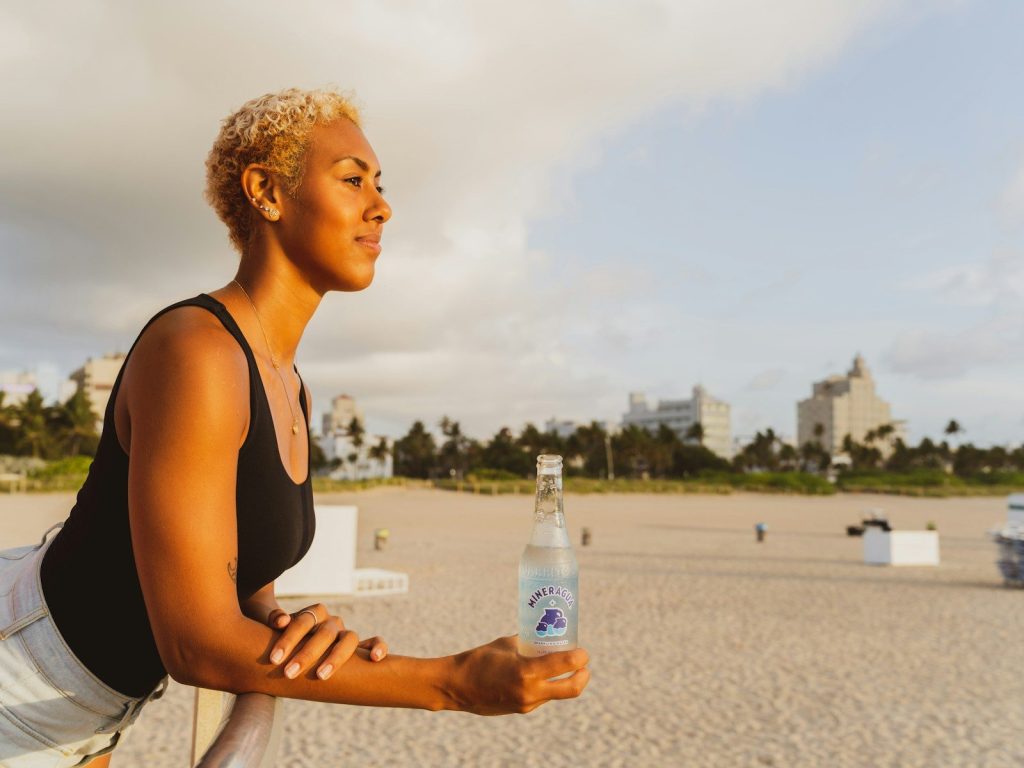 woman in black tank top holding bottled water