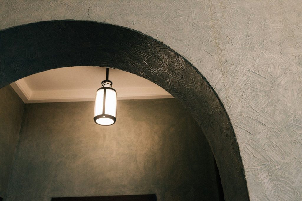 An illuminated lantern hangs under an archway.