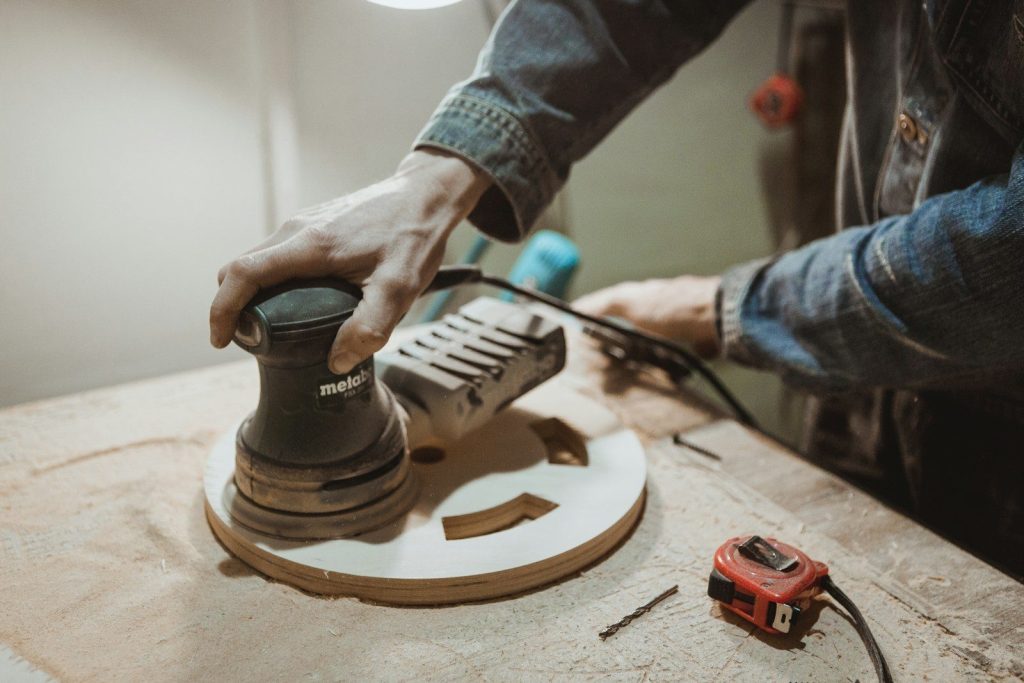 person using Makita sander