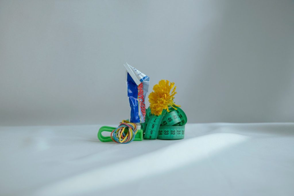 a yellow flower sitting on top of a pair of scissors