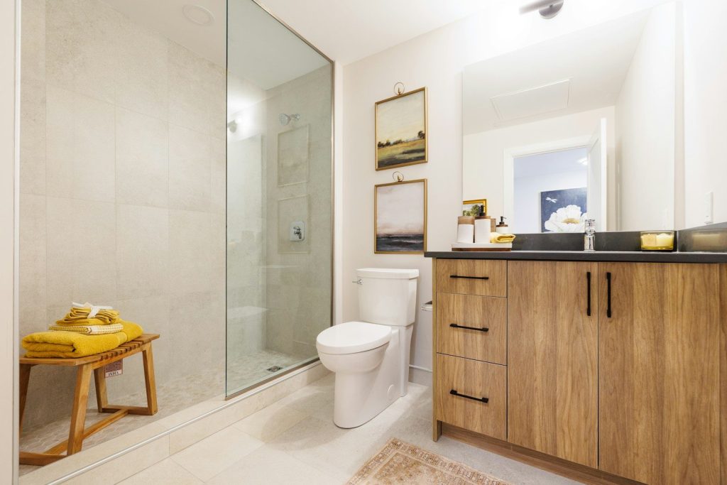 Modern bathroom with wooden vanity and glass shower.