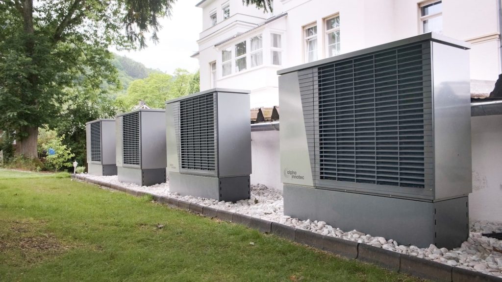 Four industrial air conditioning units lined up outside building