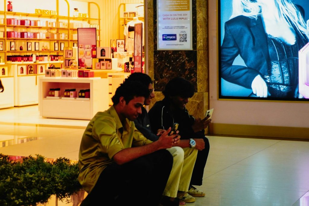 Two men looking at their phones in a store.