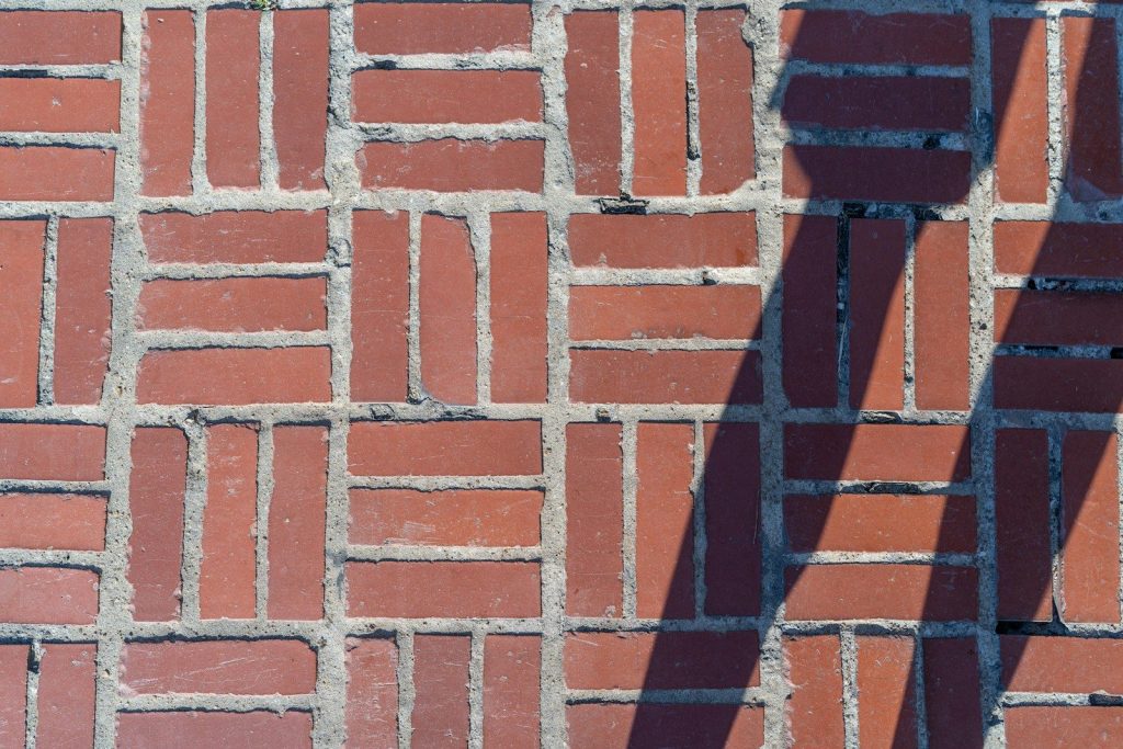a shadow of a street light on a brick wall