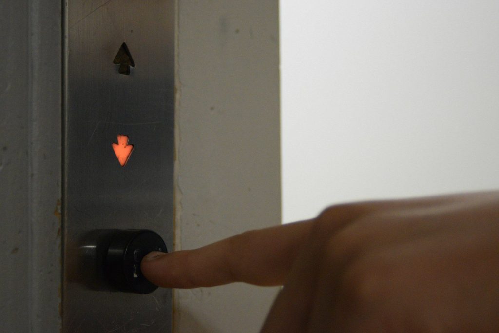 Someone is pressing the downward elevator button.