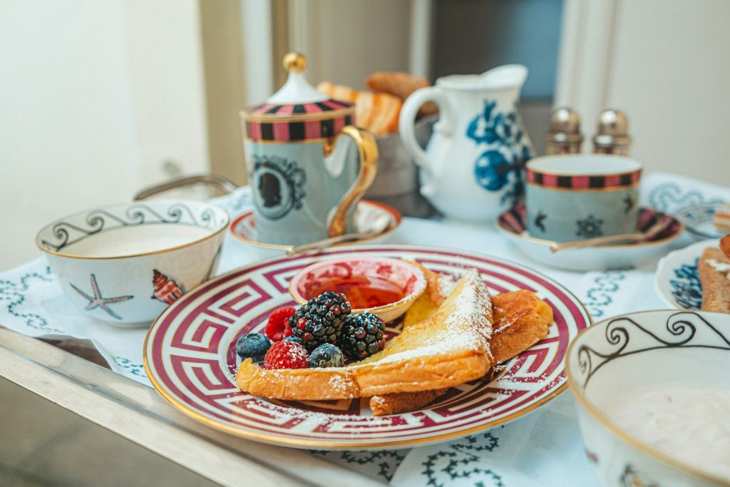 a plate of food on a table with cups and saucers