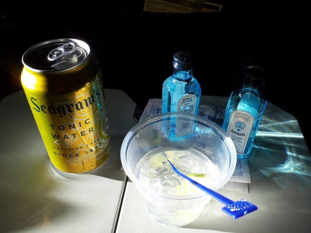 tonic water can beside liquid filled disposable cup