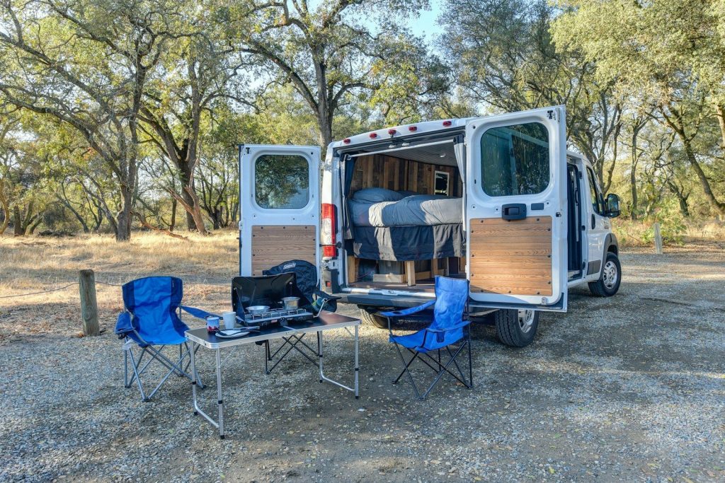 blue and black camping chair beside brown wooden door