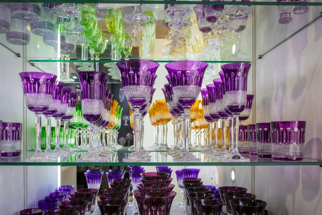 a group of glass vases are on a shelf