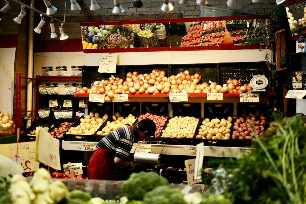 a man standing in front of a display of vegetables