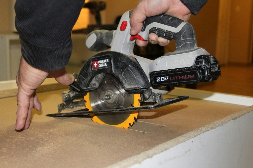Hand using a circular saw to cut wood