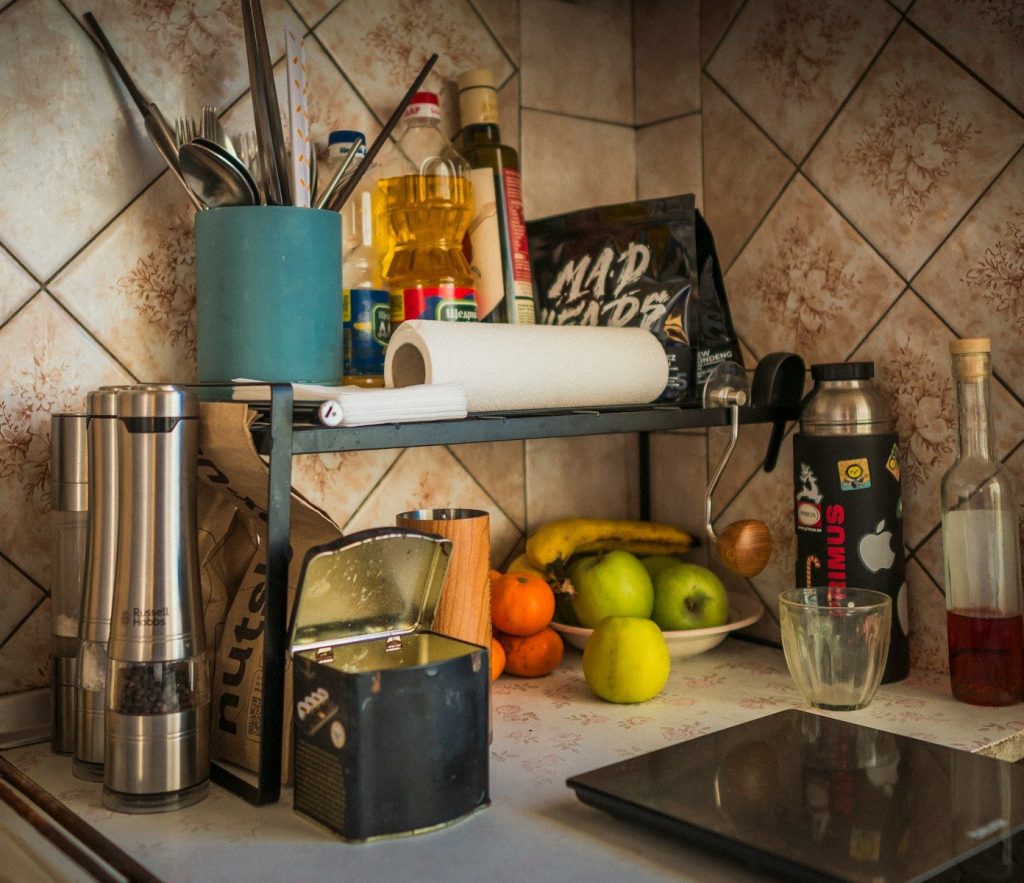 Kitchen counter with fruit, spices, and utensils.